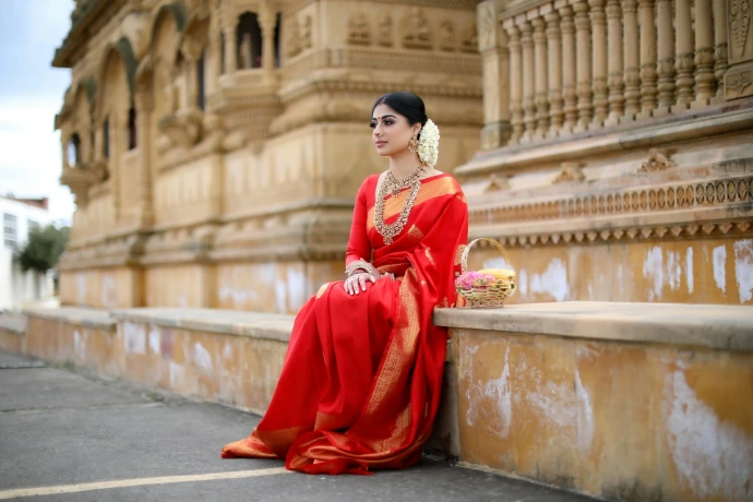 woman in red long sleeve dress sitting on gray concrete bench during daytime